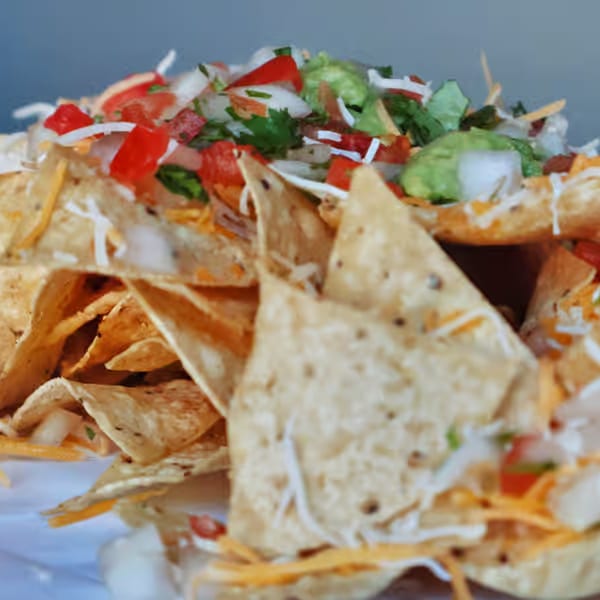 Elena's Taco Shop nachos piled high with cheese, pico de gallo, and guacamole.