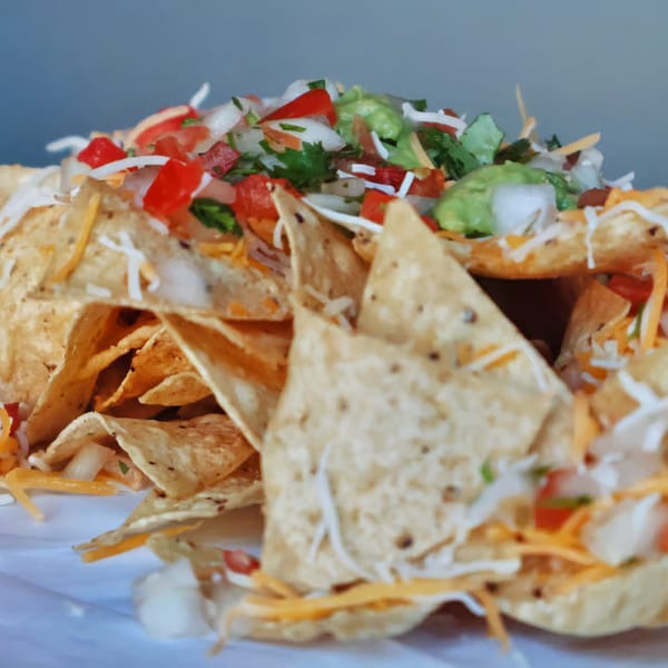 Elena's Taco Shop nachos piled high with cheese, pico de gallo, and guacamole.